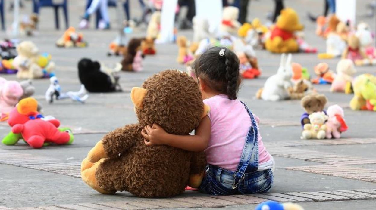 Una niña abraza un muñeco durante un "plantón de juguetes" organizado por Aldeas Infantiles SOS Colombia en contra del abuso sexual infantil en la Plaza de Bolívar, en Bogotá (Colombia)