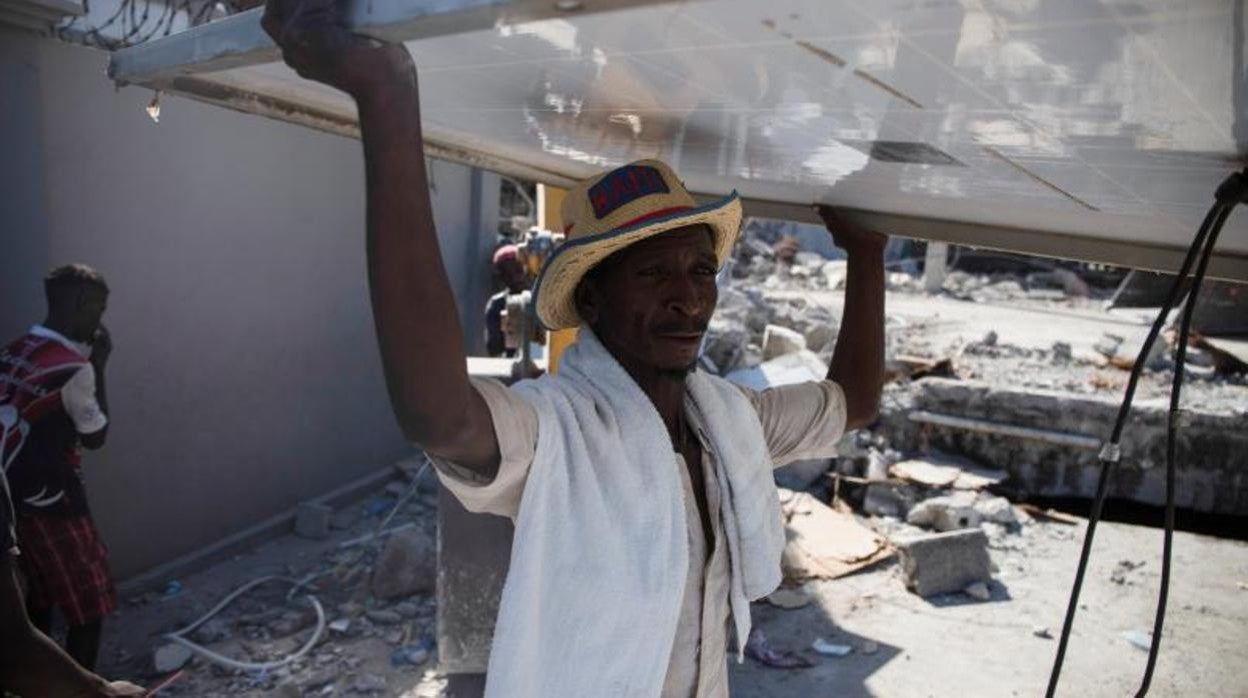 Un hombre quita los escombros de una casa tras el terremoto