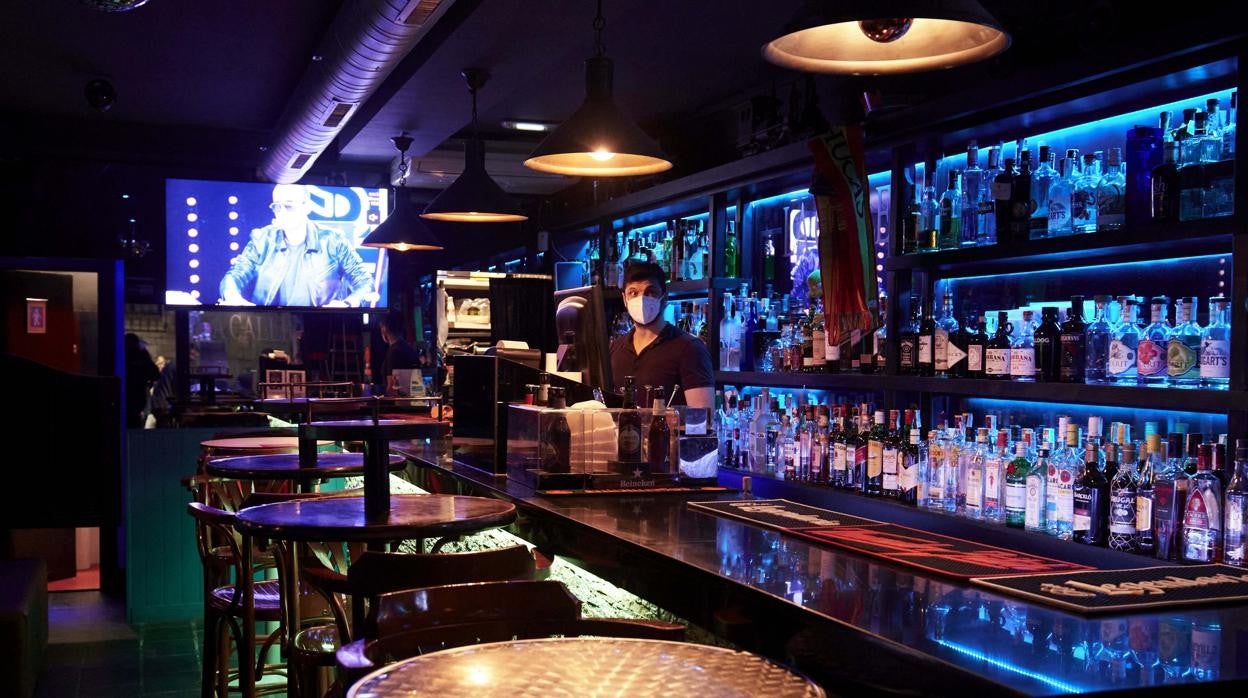 Un camarero en un local de ocio nocturno, antes de su cierre a medianoche, en Santander