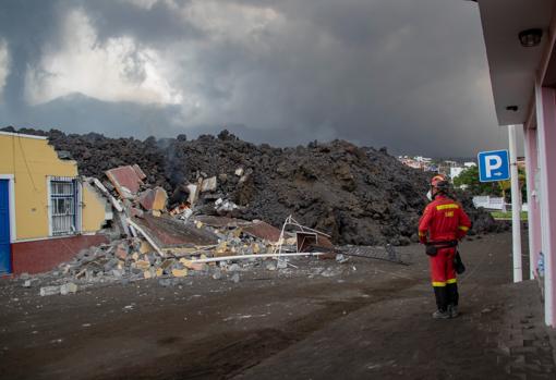 Un militar de la UME contempla la destrucción de una casa por el avance de la lava