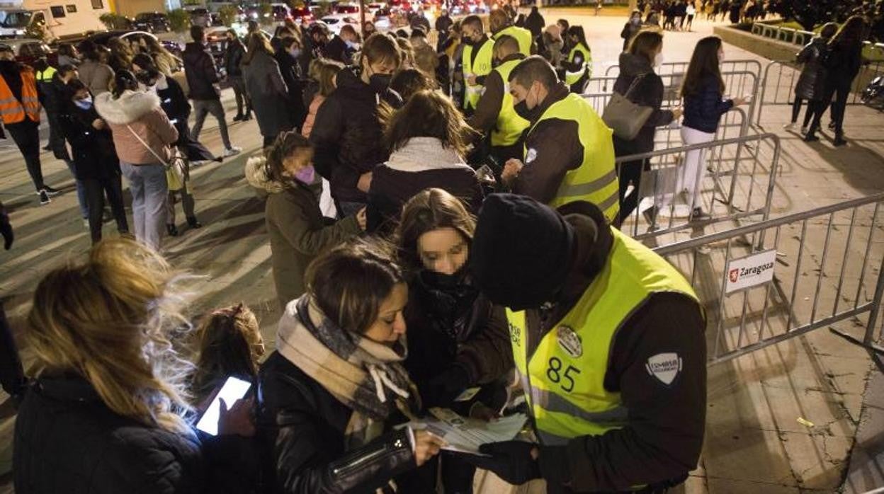 Personal de seguridad comprueba el pasaporte Covid de los asistentes a un concierto masivo en Zaragoza