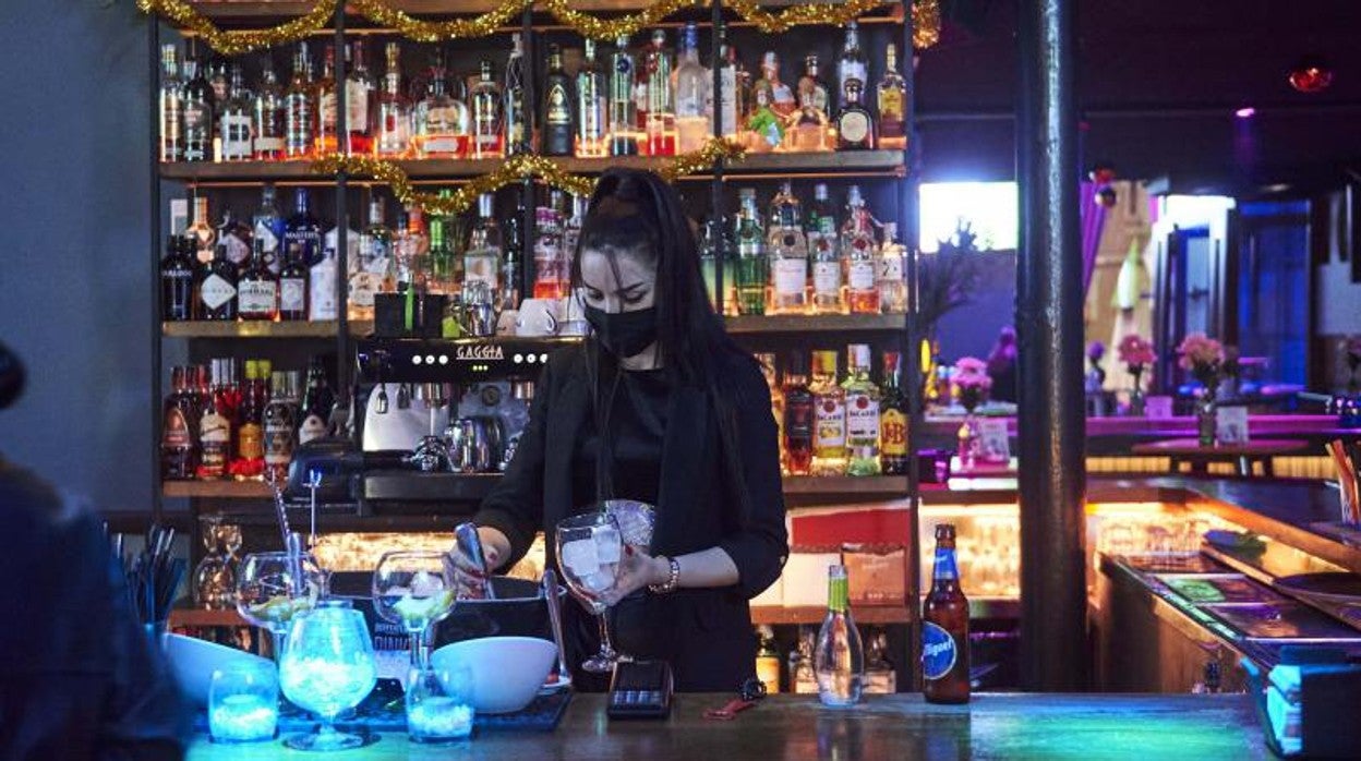 Una trabajadora prepara copas en la barra de un bar de Santander, Cantabria