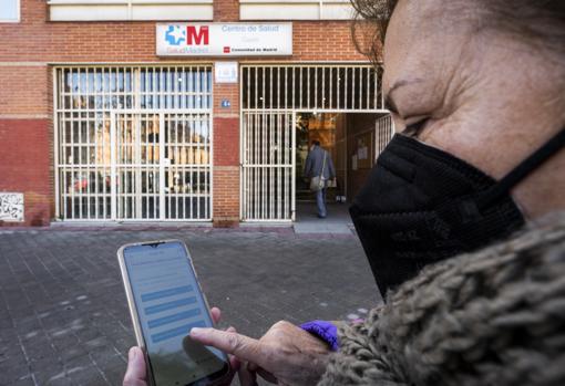 Una mujer intenta descargar el pasaporte Covid con su teléfono móvil