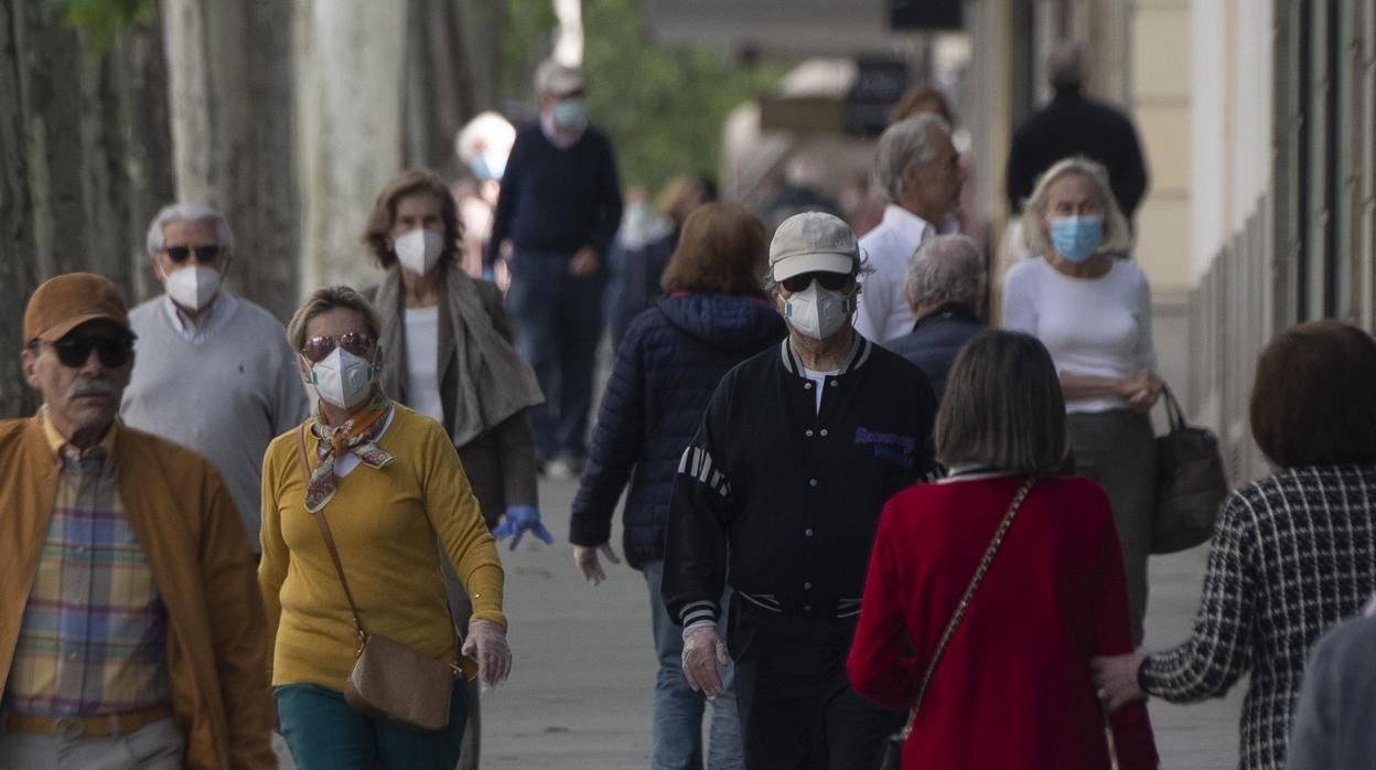 Ciudadanos pasean por una calle de Madrid con mascarilla