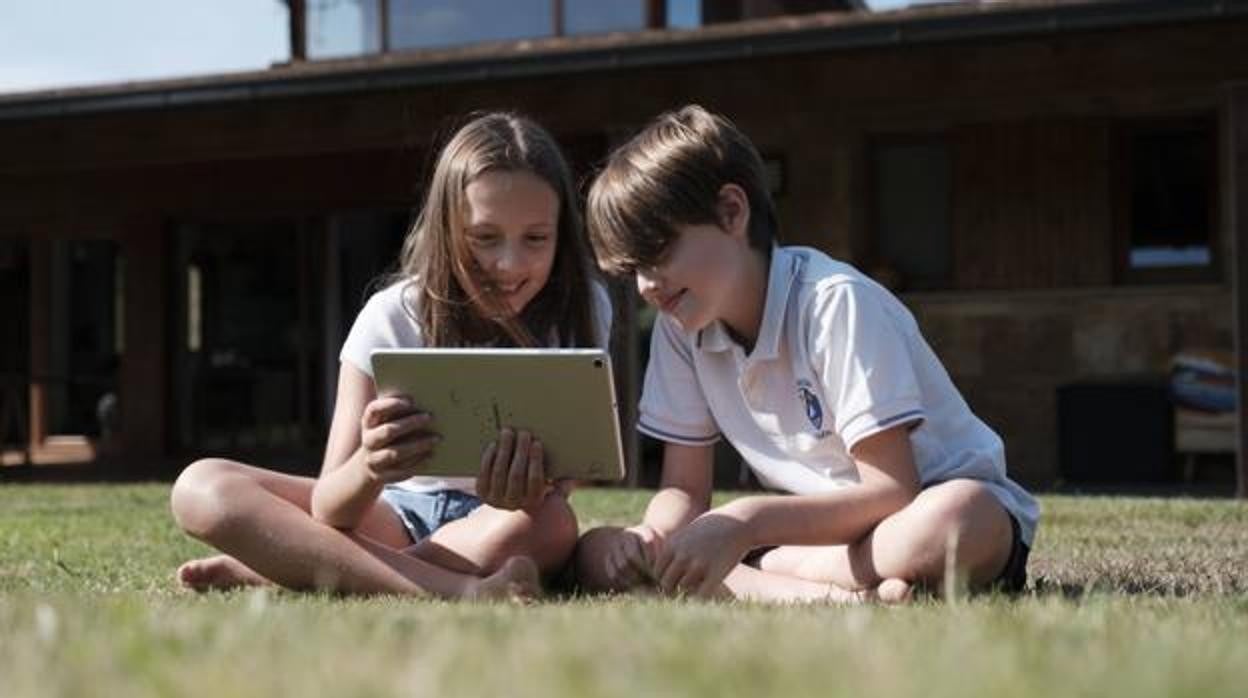 Dos niños, conectados a internet con una tablet