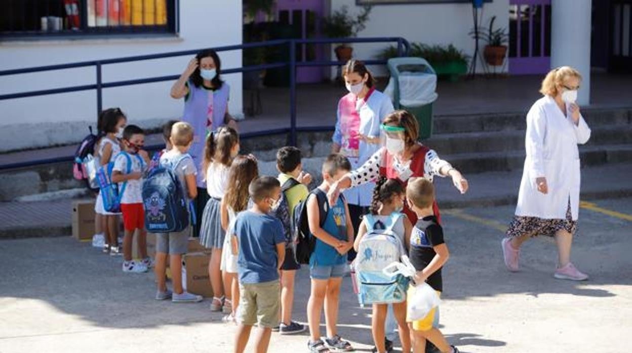 Unos niños llevan mascarilla en el patio de un colegio