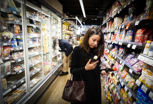 La socióloga experta en empresas, Alejandra Nuño, identifica los certificados ecológicos de los productos en un supermercado