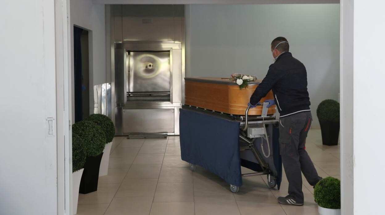 Un operario de un tanatorio barcelonés traslada el ataúd de una persona fallecida por coronavirus