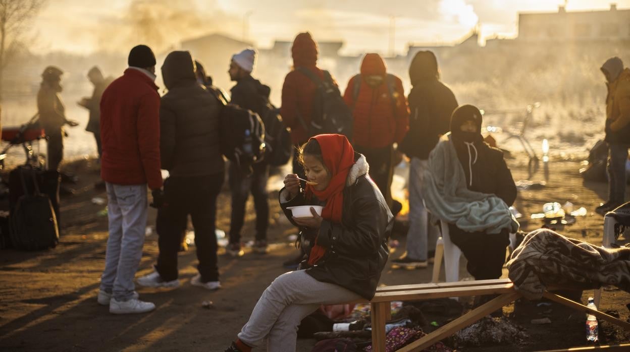 Varias personas procedentes de Ucrania, en su mayoría de nacionalidad no ucraniana, tratan de combatir el frio en las inmediaciones de la frontera con ucrania en Medyka (Polonia)