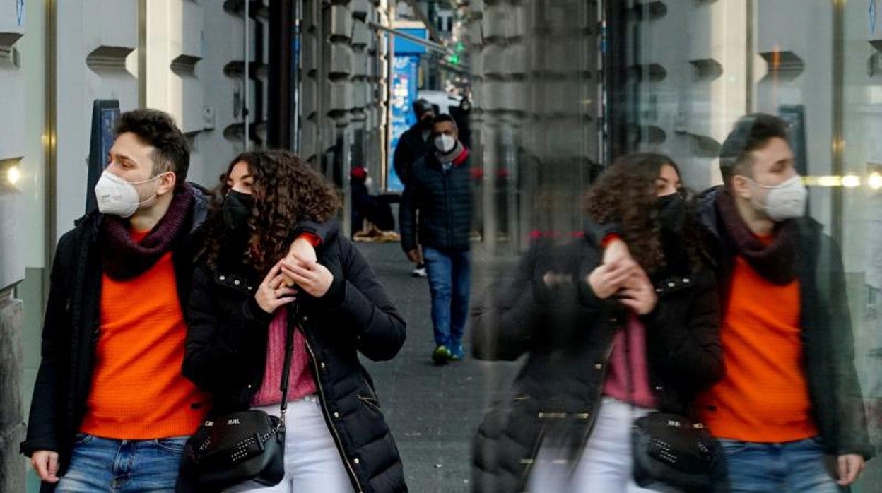 Dos viandantes portan la mascarilla al aire libre