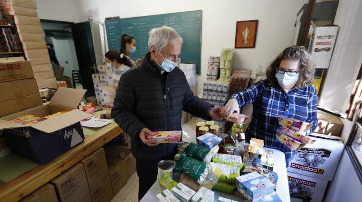 Voluntarios de Cáritas distribuyen ayuda a familias necesitadas en una parroquia de Córdoba