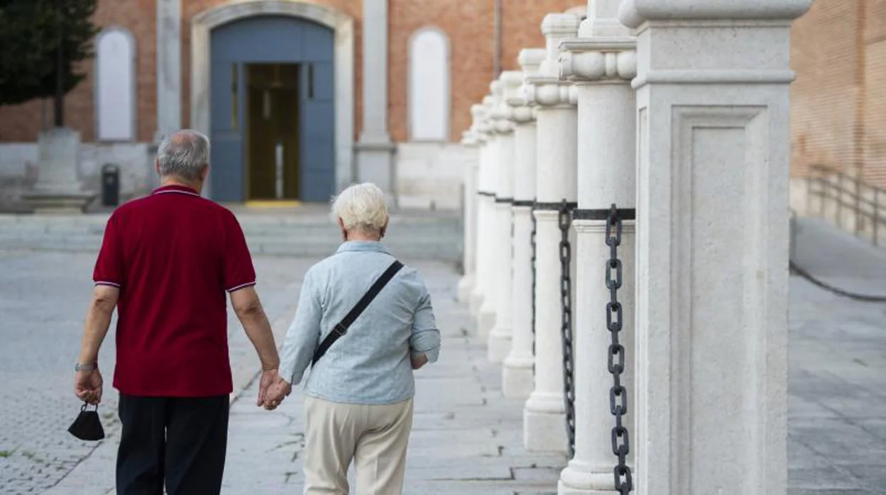 Una pareja camina por las calles de Alcalá de Henares (Madrid)