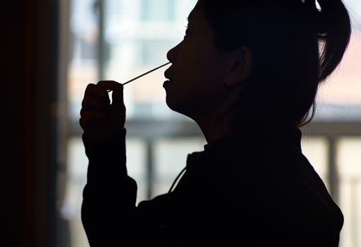 Confinada en su casa de Shanghái, la secretaria Anita Wu se hace una prueba de antígenos, que se suma a las PCR que lleva a cabo el Gobierno