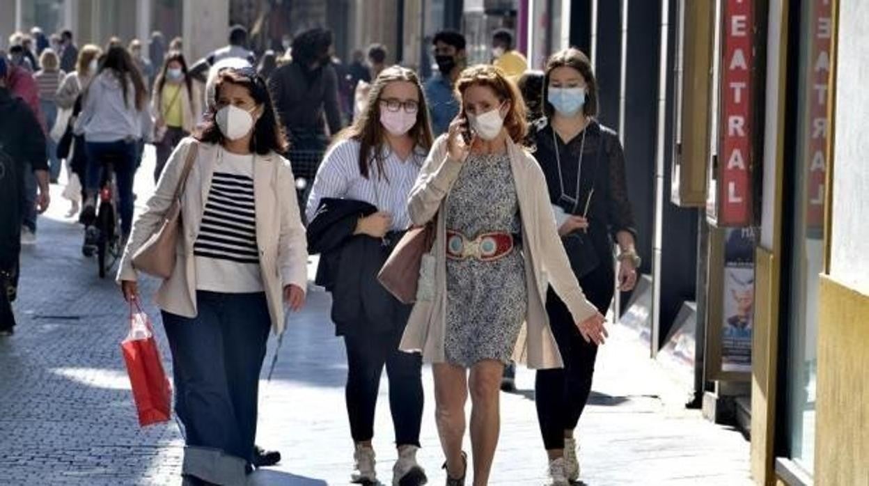 Viandantes con mascarilla por la calle