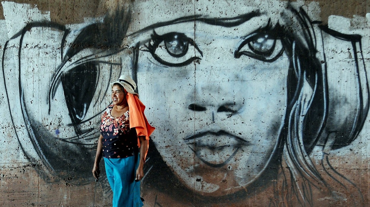 Una mujer hondureña camina en frente de un grafiti en la capital, Tegucigalpa (Honduras), el pasado 8-M, Día Internacional de la Mujer