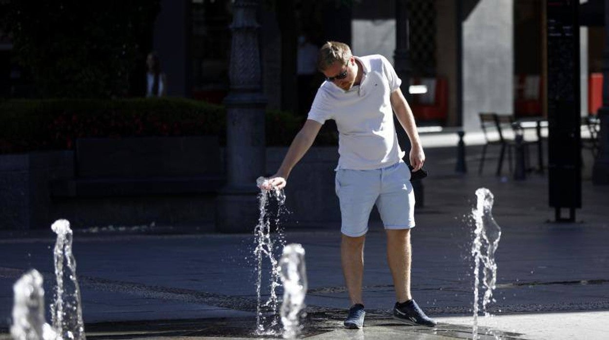 Un hombre se refresca en la calle ante las altas temperaturas