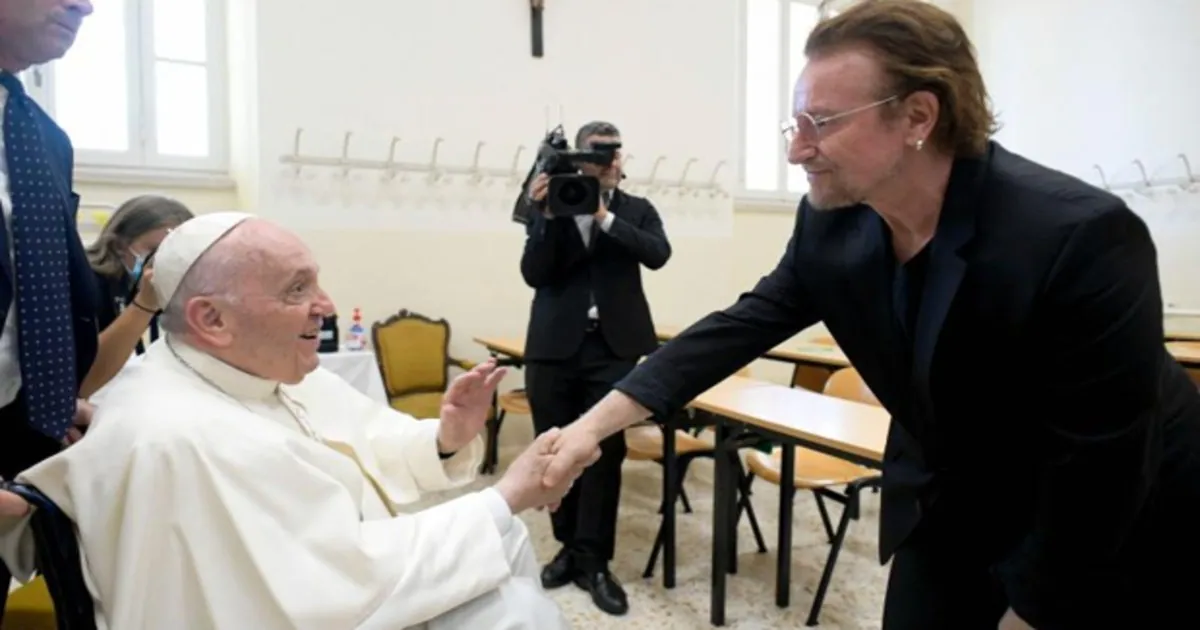 El cantante de U2, Bono, saluda al Papa Francisco
