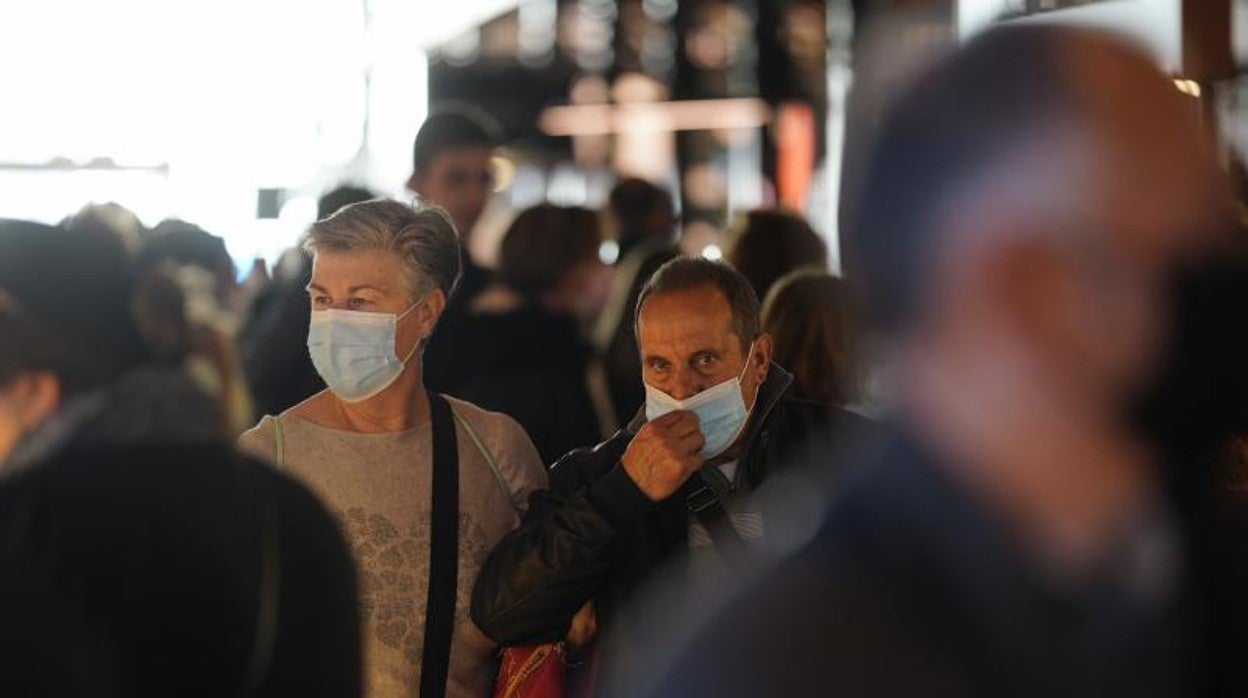 Un hombre se tapa la cara con una mascarilla en el interior de un mercado