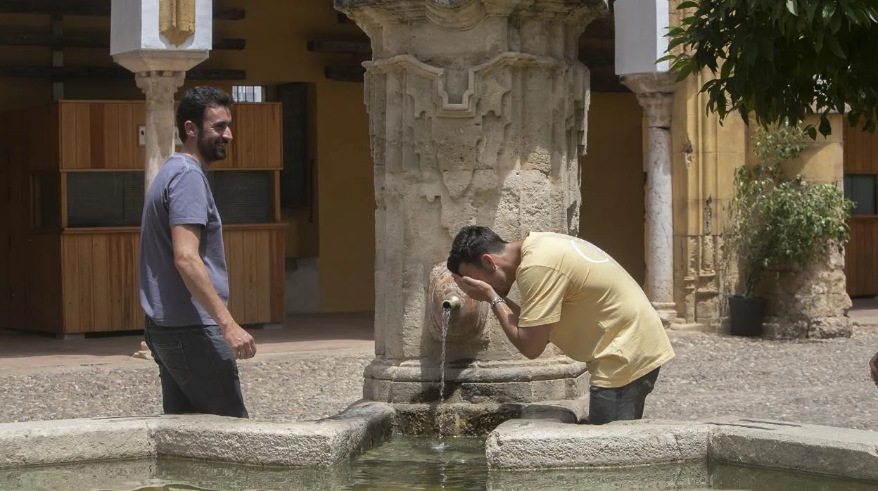 Un hombre busca refrescarse ante el calor en una fuente en Córdoba