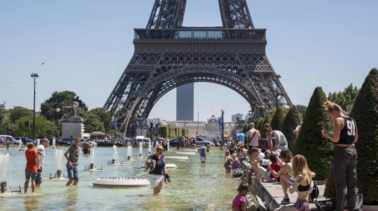 Multitud de personas se refrescan en las fuentes de los jardines del Trocadero junto a la Torre Eiffel en París, Francia, en 2016