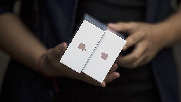 Un empleado de Apple con las cajas de los últimos terminales de la compañía, iPhone 6S y 6s Plus