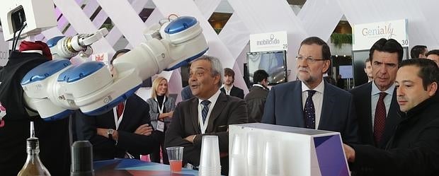 El presidente del Gobierno observa el funcionamiento de un robot durante la inauguración de FICOD