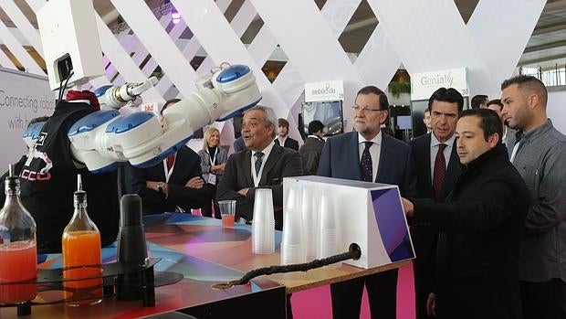 El presidente del Gobierno observa el funcionamiento de un robot durante la inauguración de FICOD