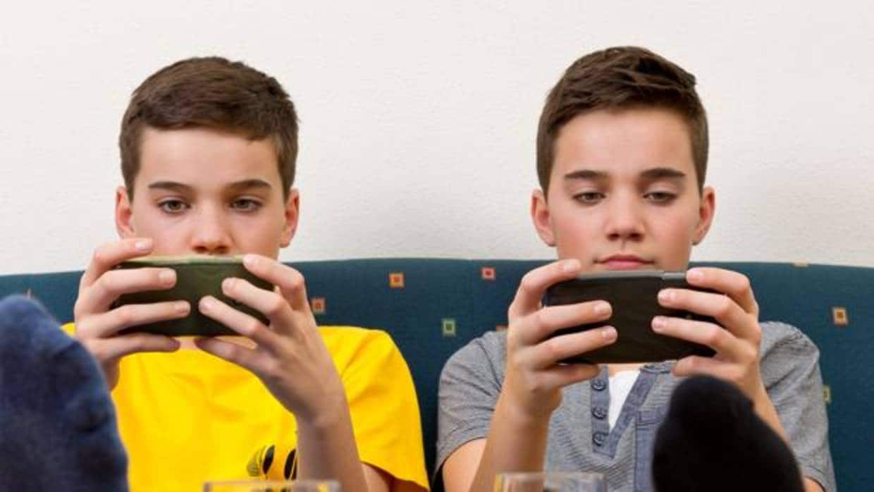 Dos chicos menores jugando con el «smartphone»