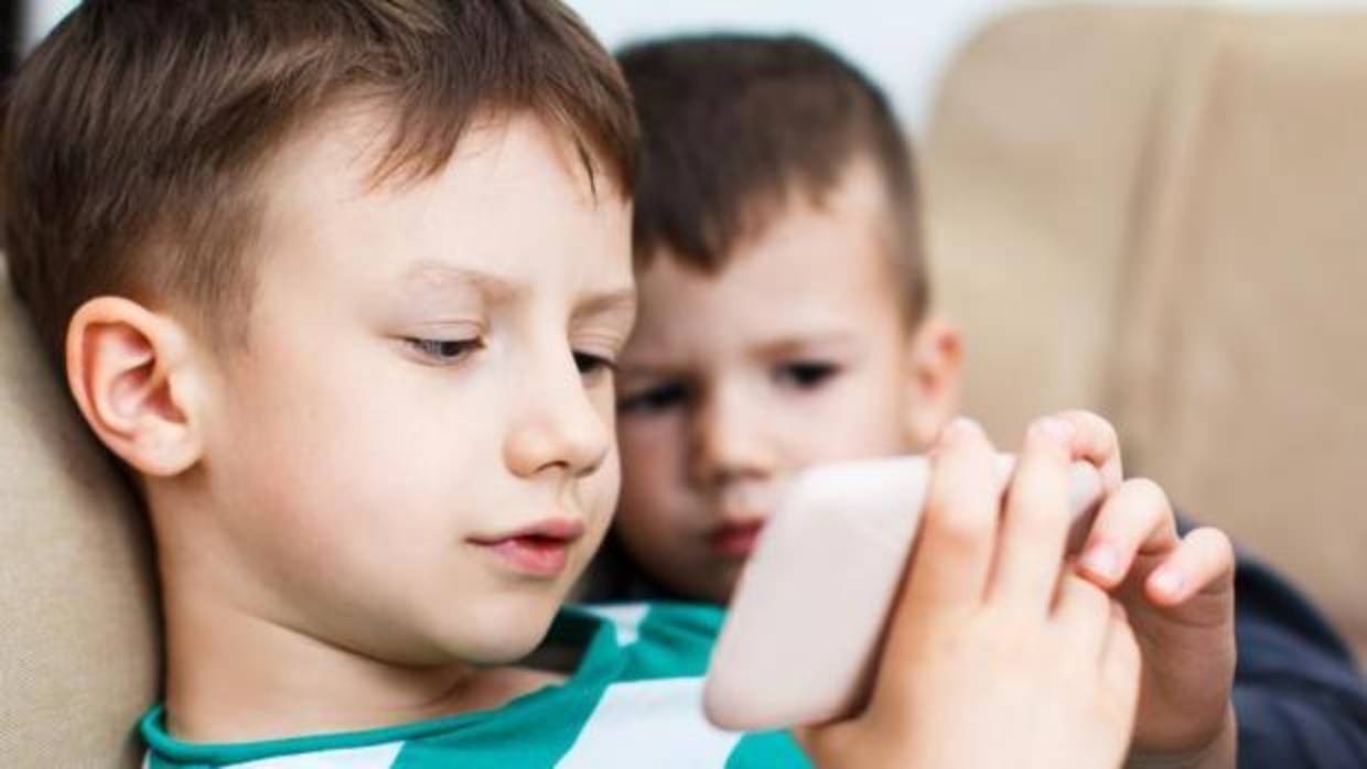 Unos niños mirando un smartphone