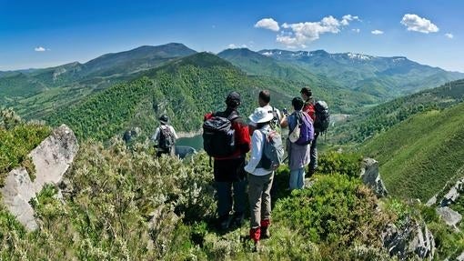 Un grupo de senderistas hace un alto en el embalse de la Cohílla del Camino del Potro, en el Parque Natural Saja-Besaya