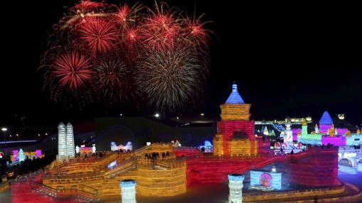 Fuegos artificiales estallan sobre as esculturas de hielo expuestas en la trigésimo tercera edición del Festival Internacional de Hielo y Nieve de Harbin