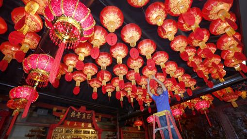 Un trabajador indonesio coloca unos faros chinos con motivo de la celebración del Año Nuevo Chino, en un templo chino en Bogor, Indonesia