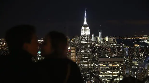 Una pareja se besa con vistas al Empire State Building y al World Trade Center