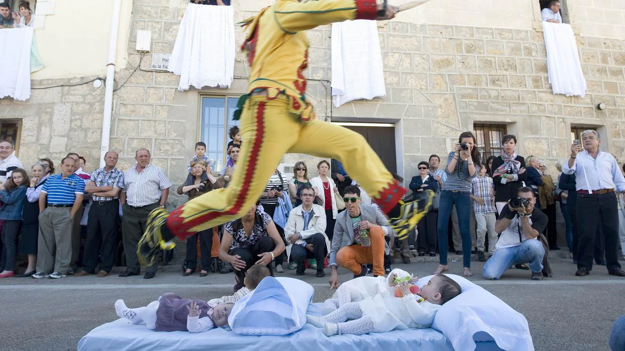 Los colachos saltan sobre los niños para protegerles de enfermedades, en Castrillo de Murcia (Burgos)
