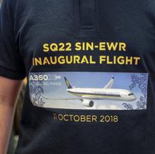 Un hombre viste una camiseta conmemorativa del vuelo SQ22 de la aerolínea Singapore Airlines en el aeropuerto de Changi en Singapur