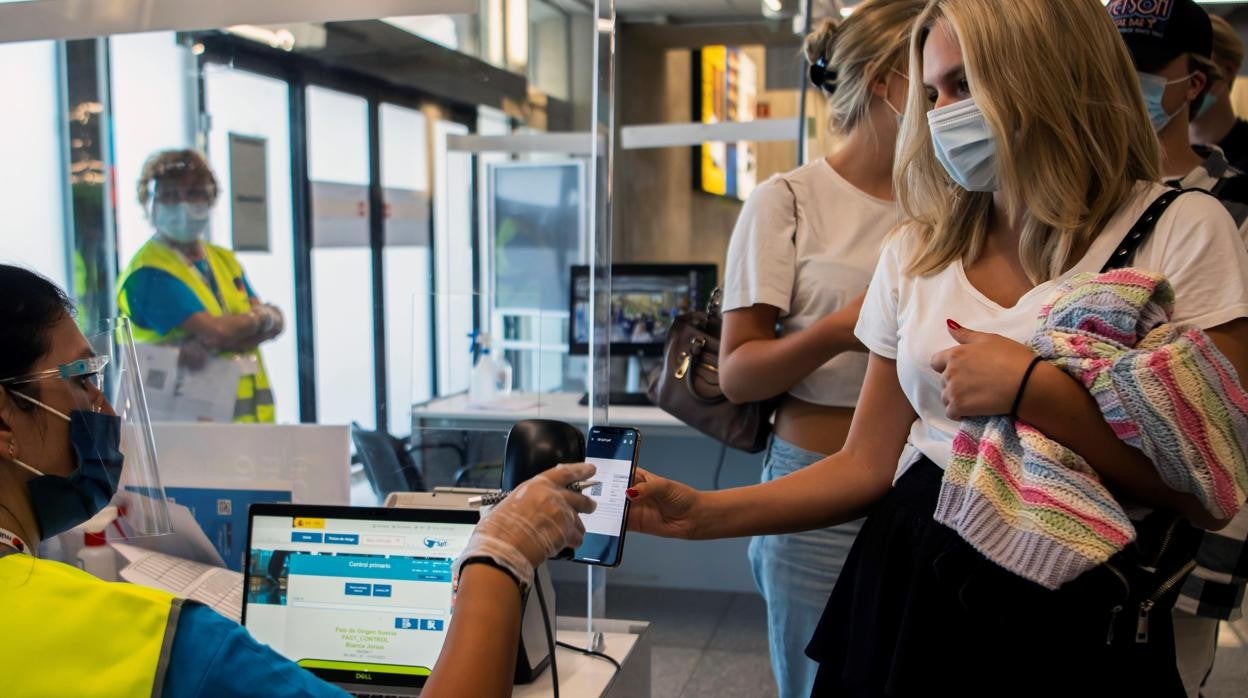 Una turista muestra el certificado digital sanitario en el aeropuerto de Mallorca