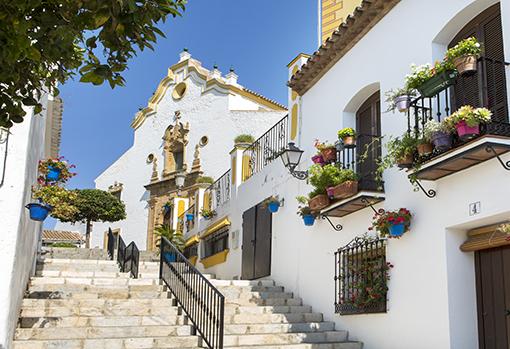 Calles empinadas junto a las casas encaladas con macetas de geranios en el centro de Estepona