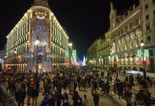 Las luces de Navidad iluminan la noche en el centro de Madrid, con el Centro Canalejas en primer plano y la Puerta del Sol al fondo